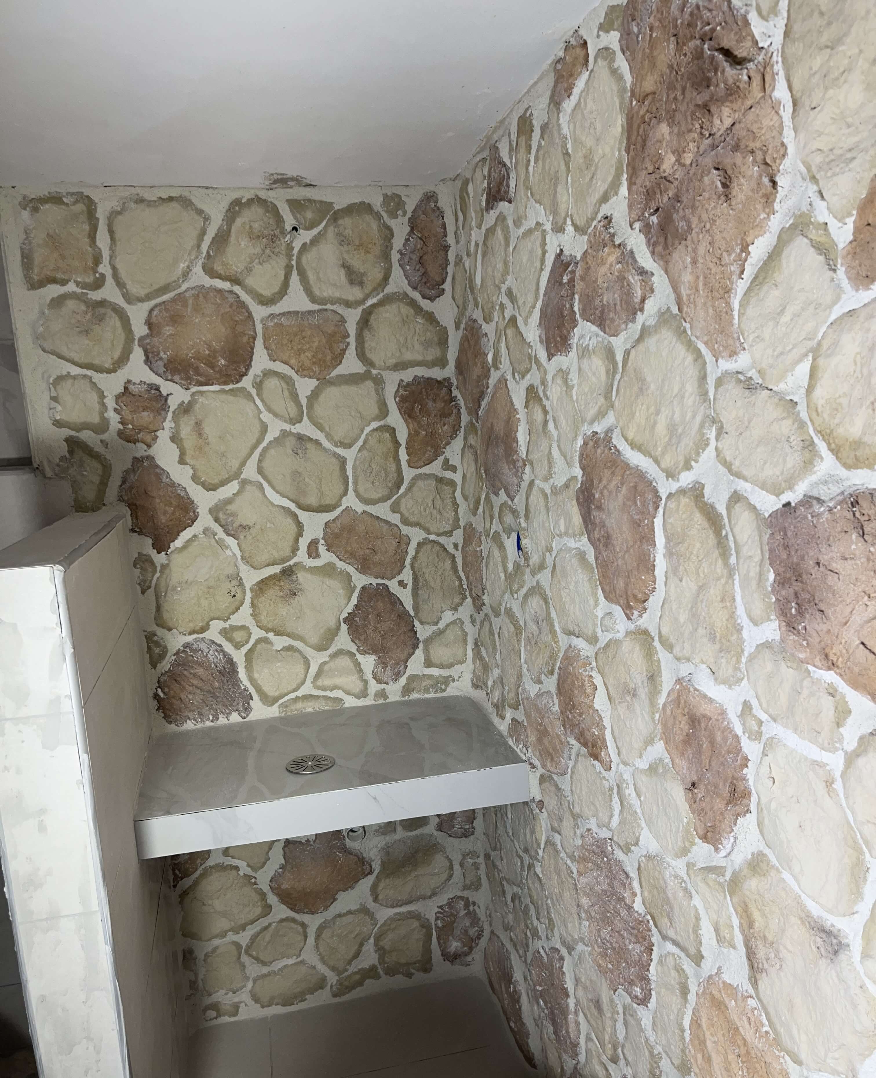 Τοποθέτηση πλακιδίων τύπου πέτρας σε τοίχο μπάνιου